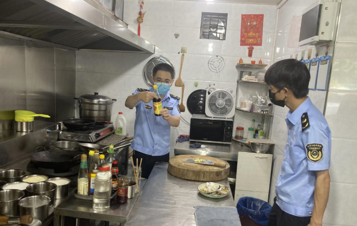 图为该局执法人员在一家餐饮店后厨检查食品安全。
