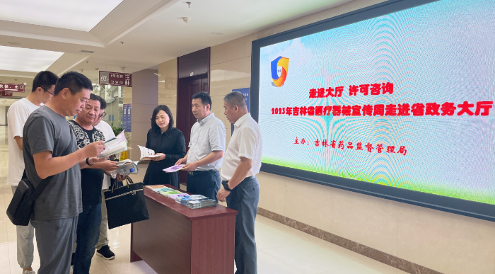 图为工作人员向企业代表发放医疗器械审批办事流程宣传册。（叶阳欢摄）